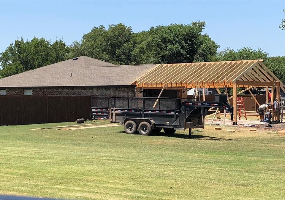 A trailer is parked in front of a house under construction.