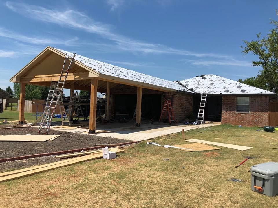 A house is being built with a roof that is being installed.