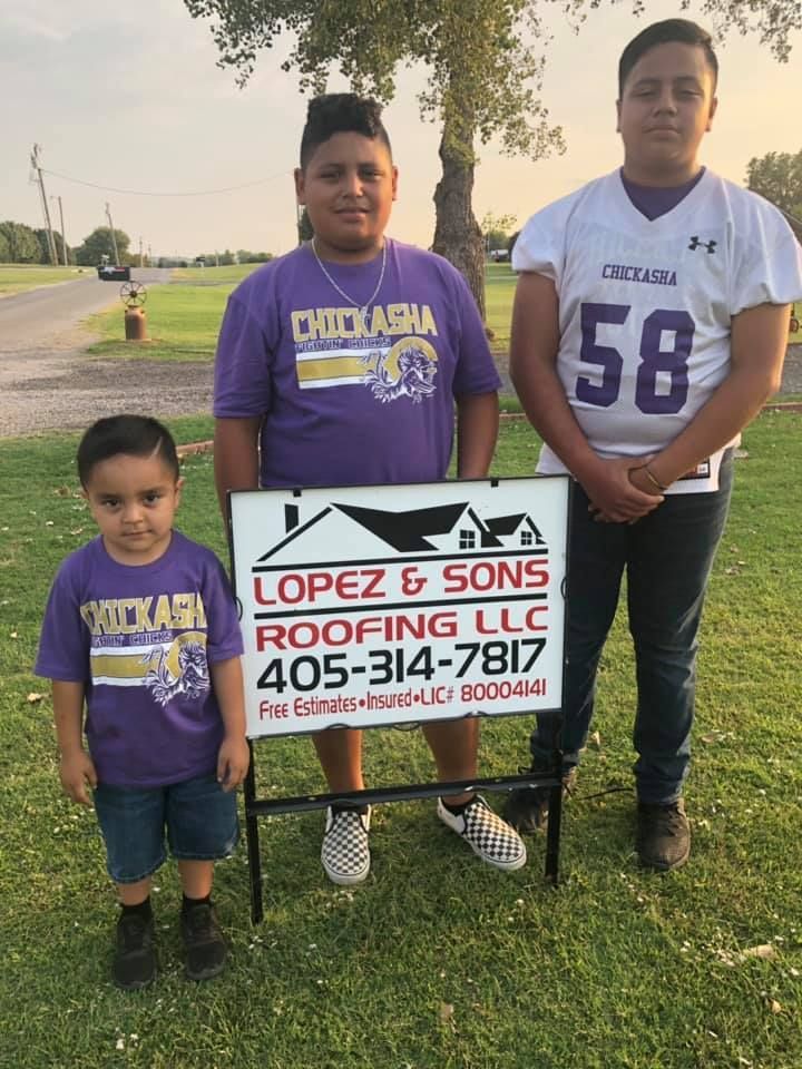 Three boys are standing next to each other holding a sign for lopez & sons roofing llc.
