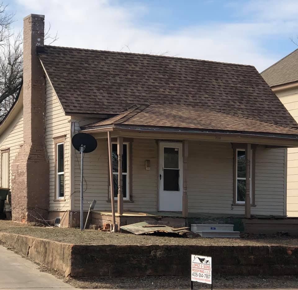 A small house with a porch and a sign that says 