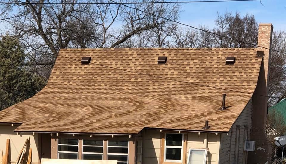 A house with a brown roof is being remodeled.