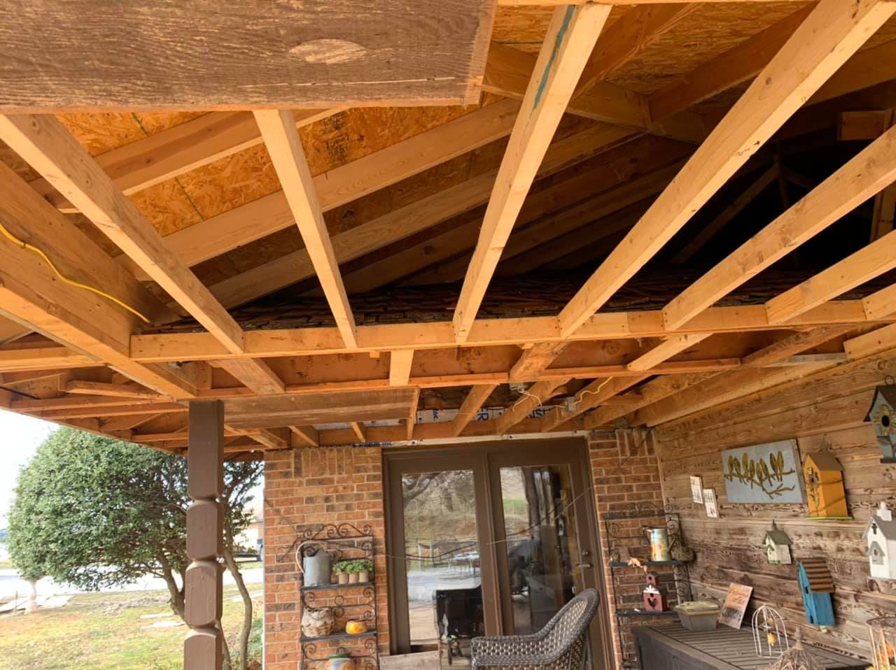 A wooden structure is being built on top of a brick building.