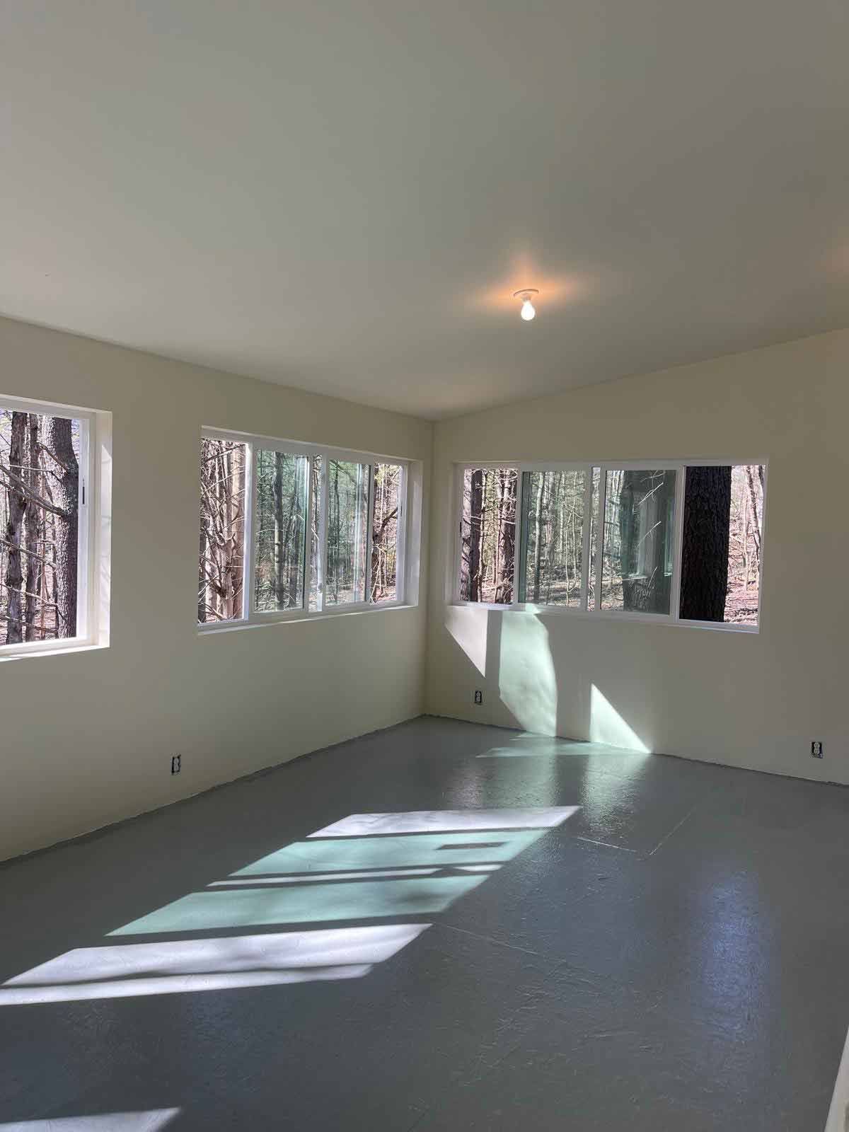 A Large Empty Room With A Lot Of Windows And A Light On The Ceiling. — Kingston, NY — T.I. Contracting
