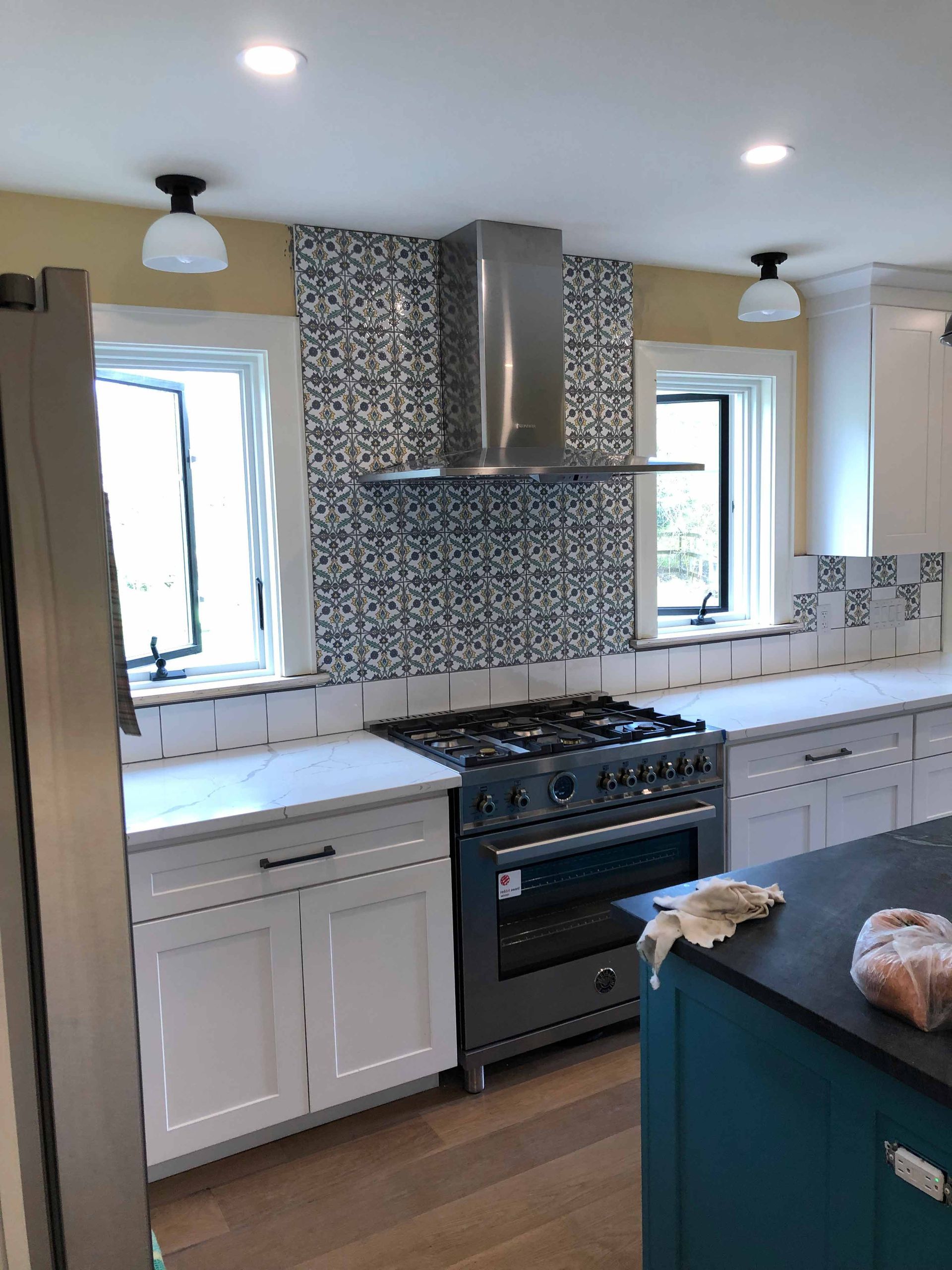 A Kitchen With White Cabinets , A Stove , And A Window — Kingston, NY — T.I. Contracting