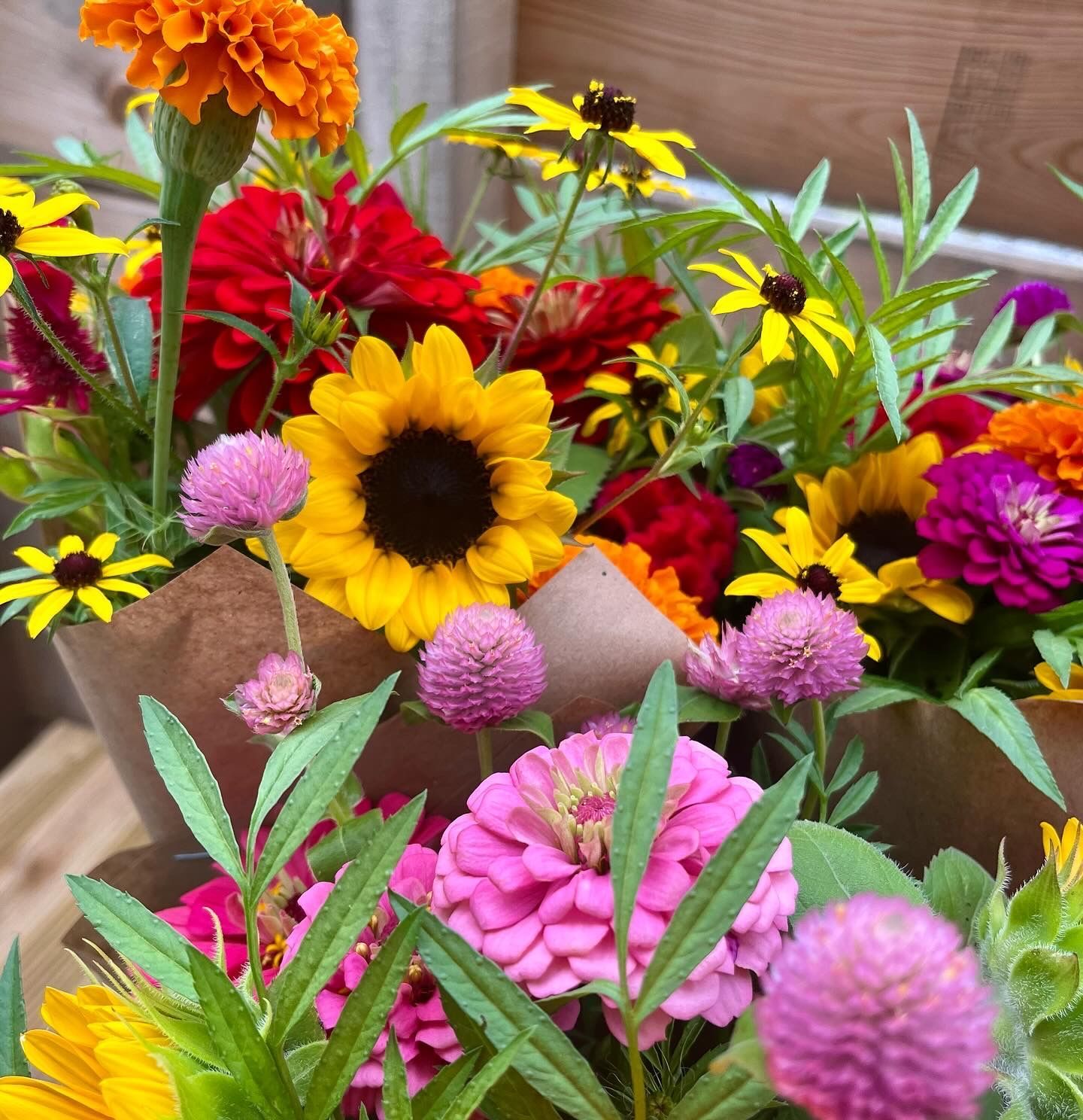 Flowers bouquets with a sunflower, gomphrena, rudbeckia and zinnias 