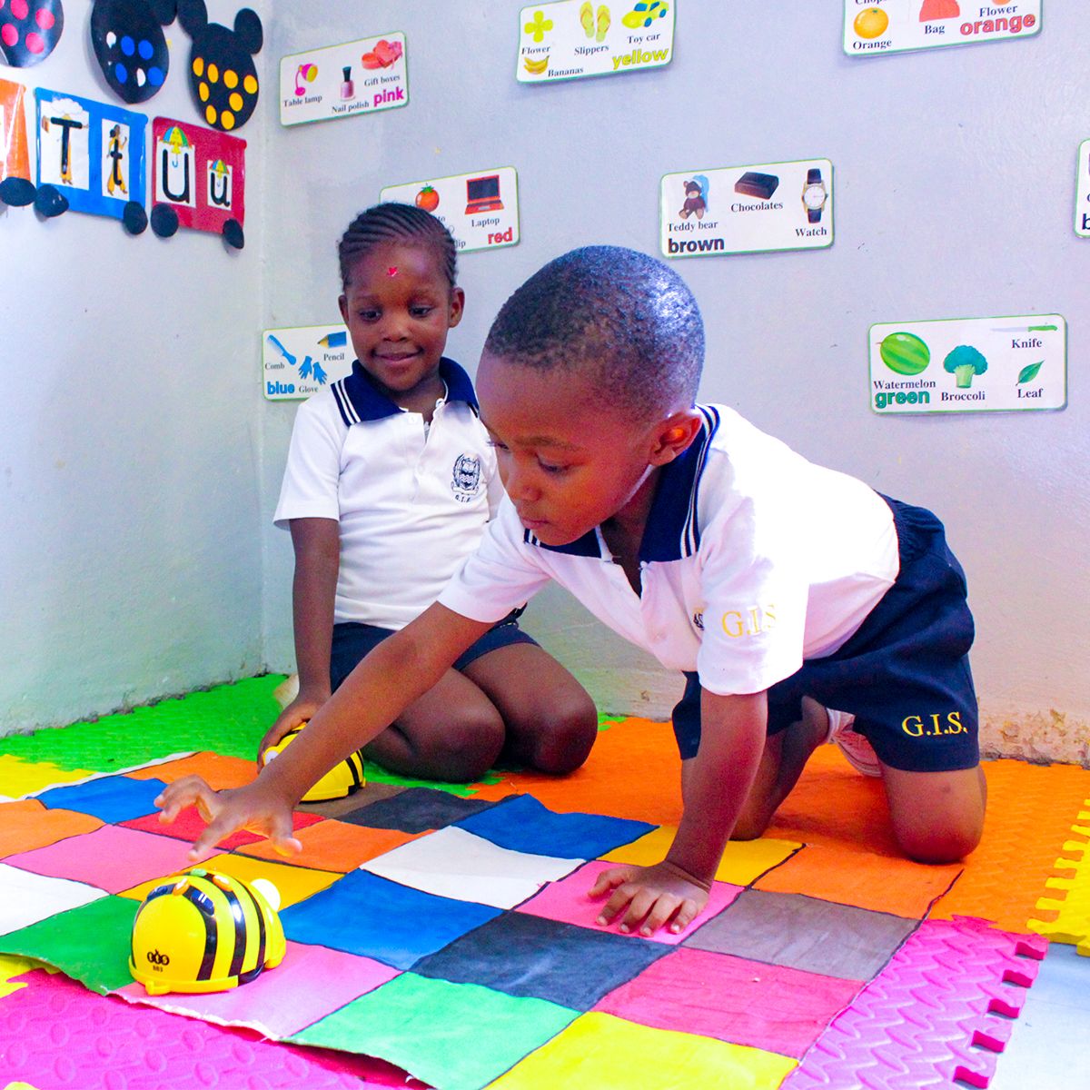 A boy and a girl are playing with a bee toy