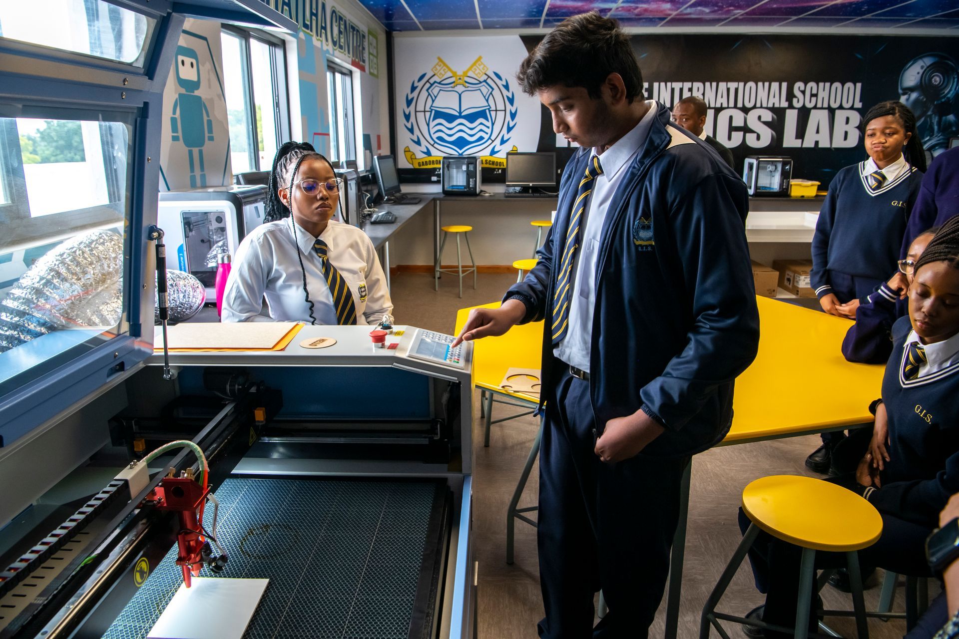 A group of students are working on a machine in a lab.