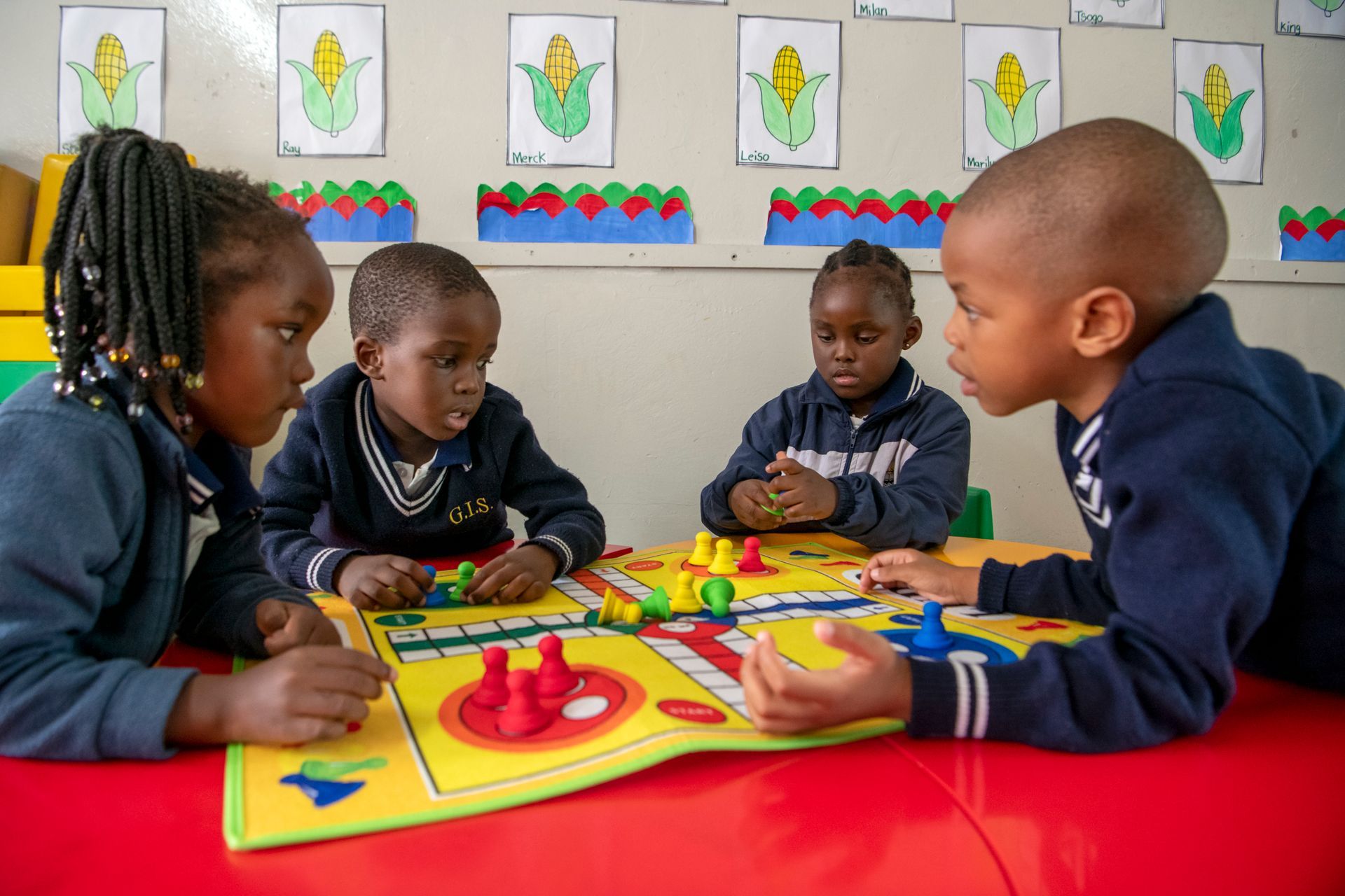 A group of children are sitting at a table playing a board game.