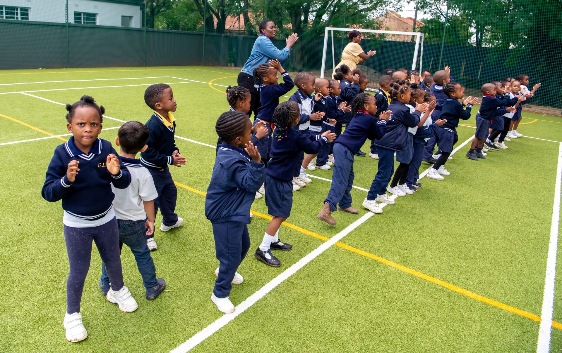 A group of children are dancing on a field.