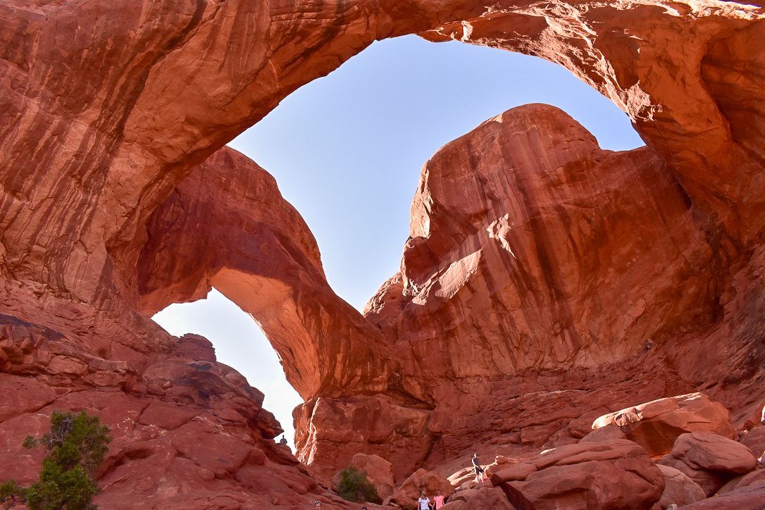 Red rock double arch formation against a blue sky in Arches National Park, Utah.
