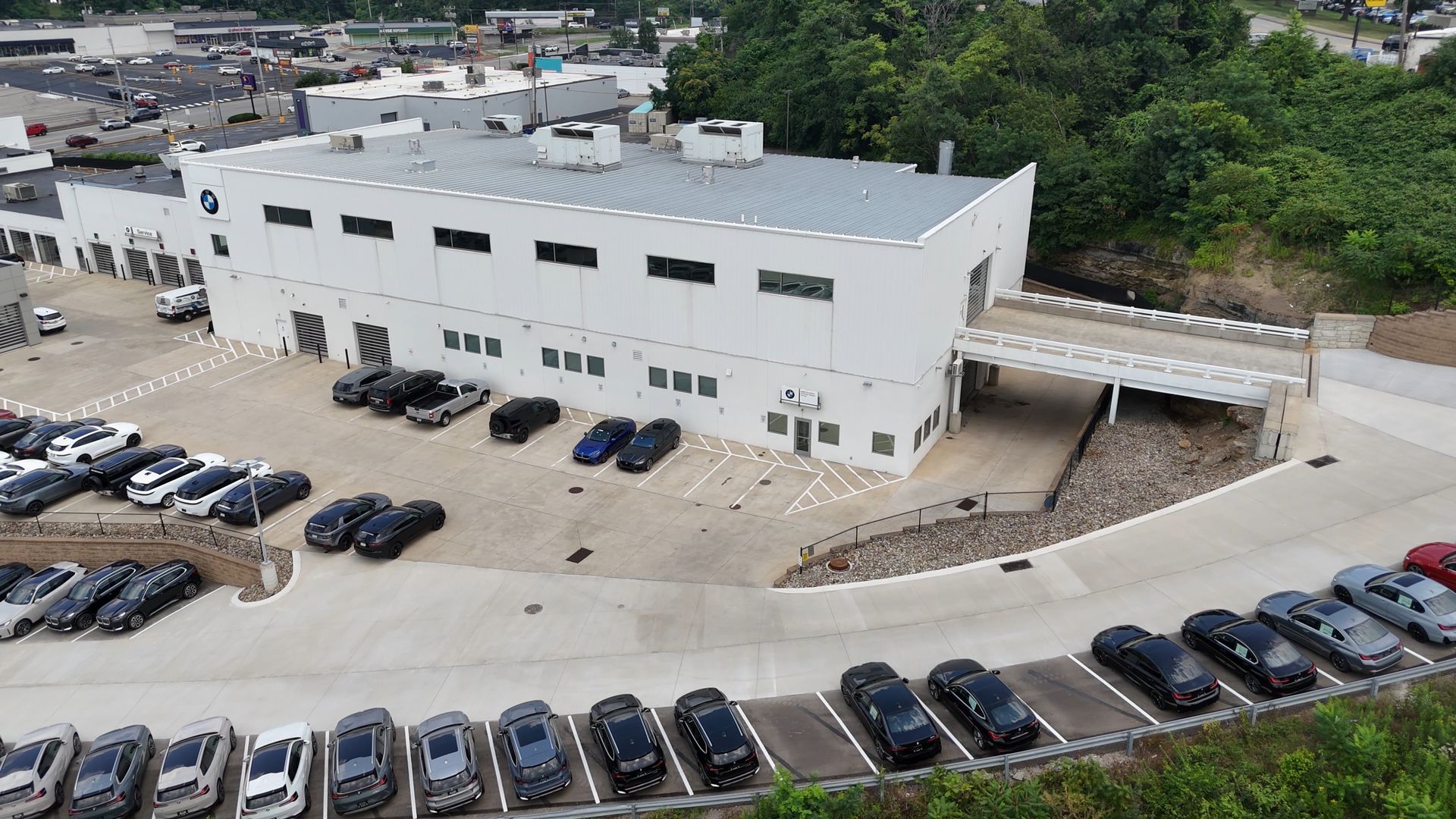 White commercial building with cars parked in front.