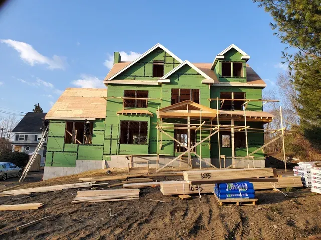 A house that is being built with green siding