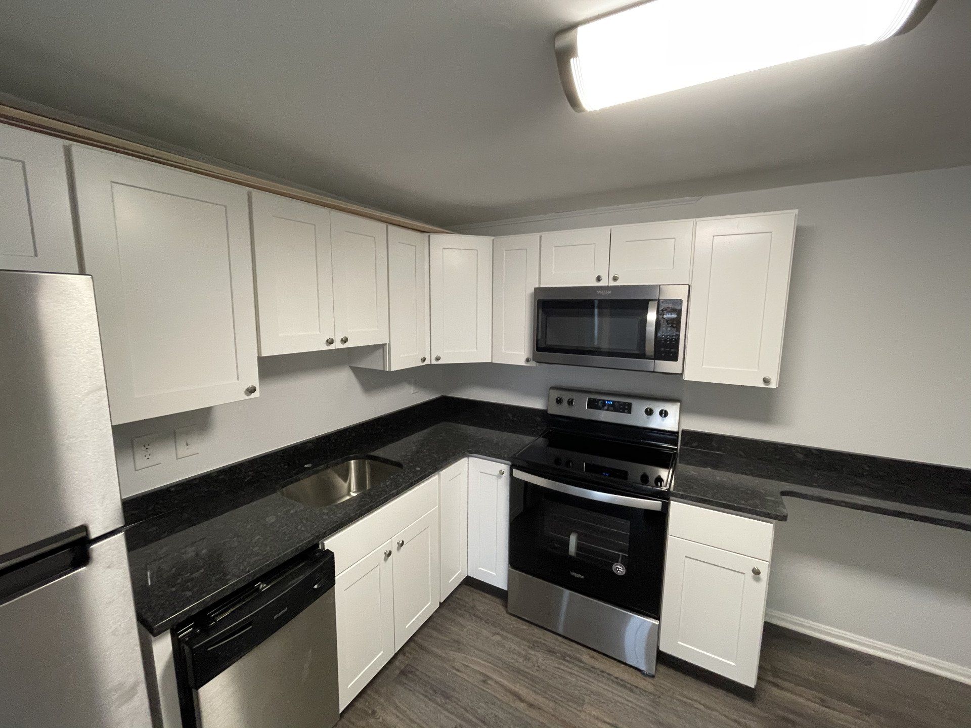 A kitchen with stainless steel appliances and white cabinets