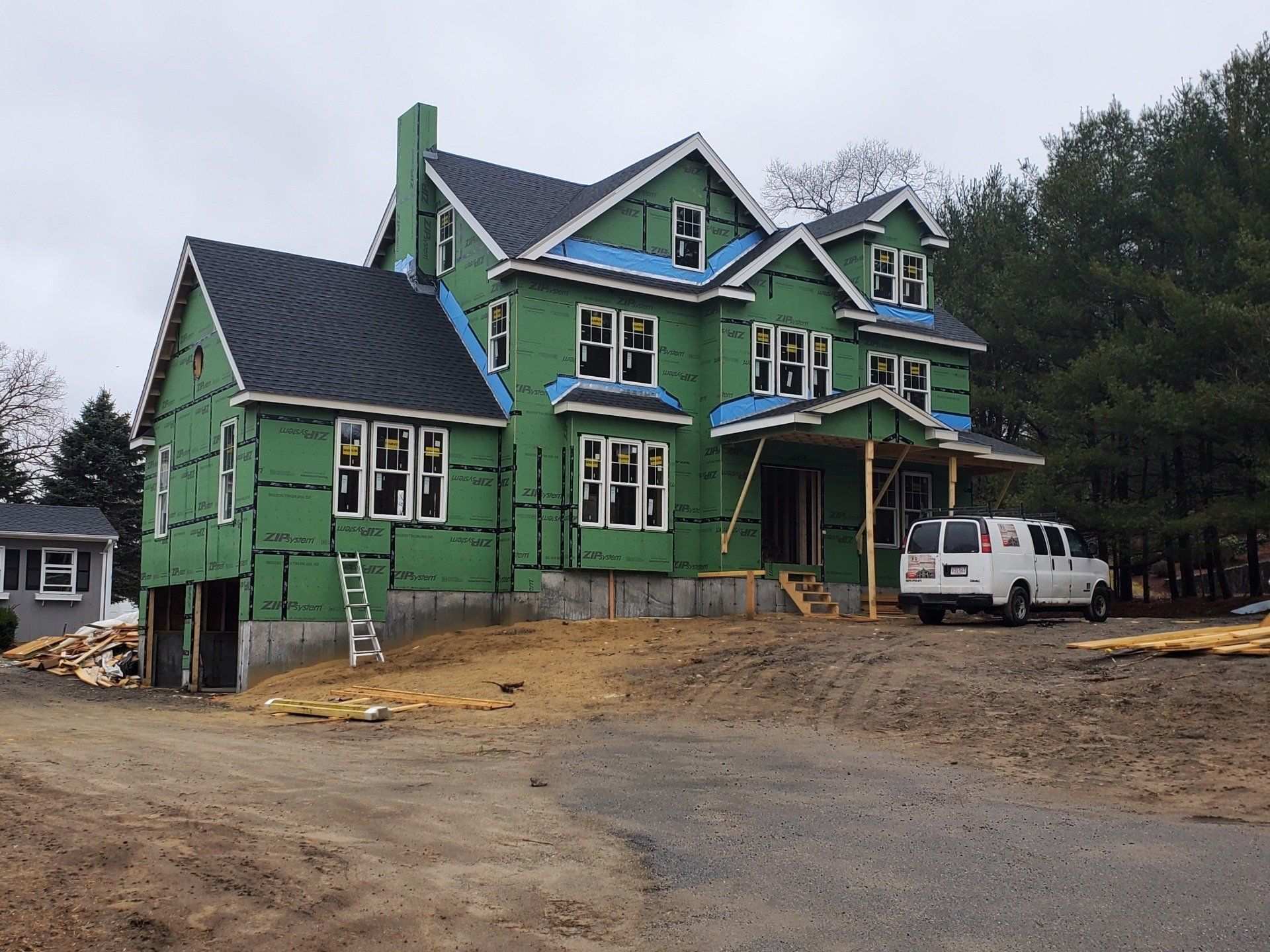 A large house under construction with a white van parked in front of it.