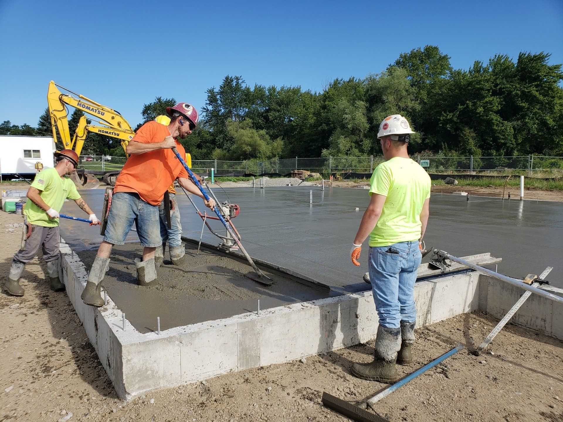 A group of construction workers are working on a concrete foundation.