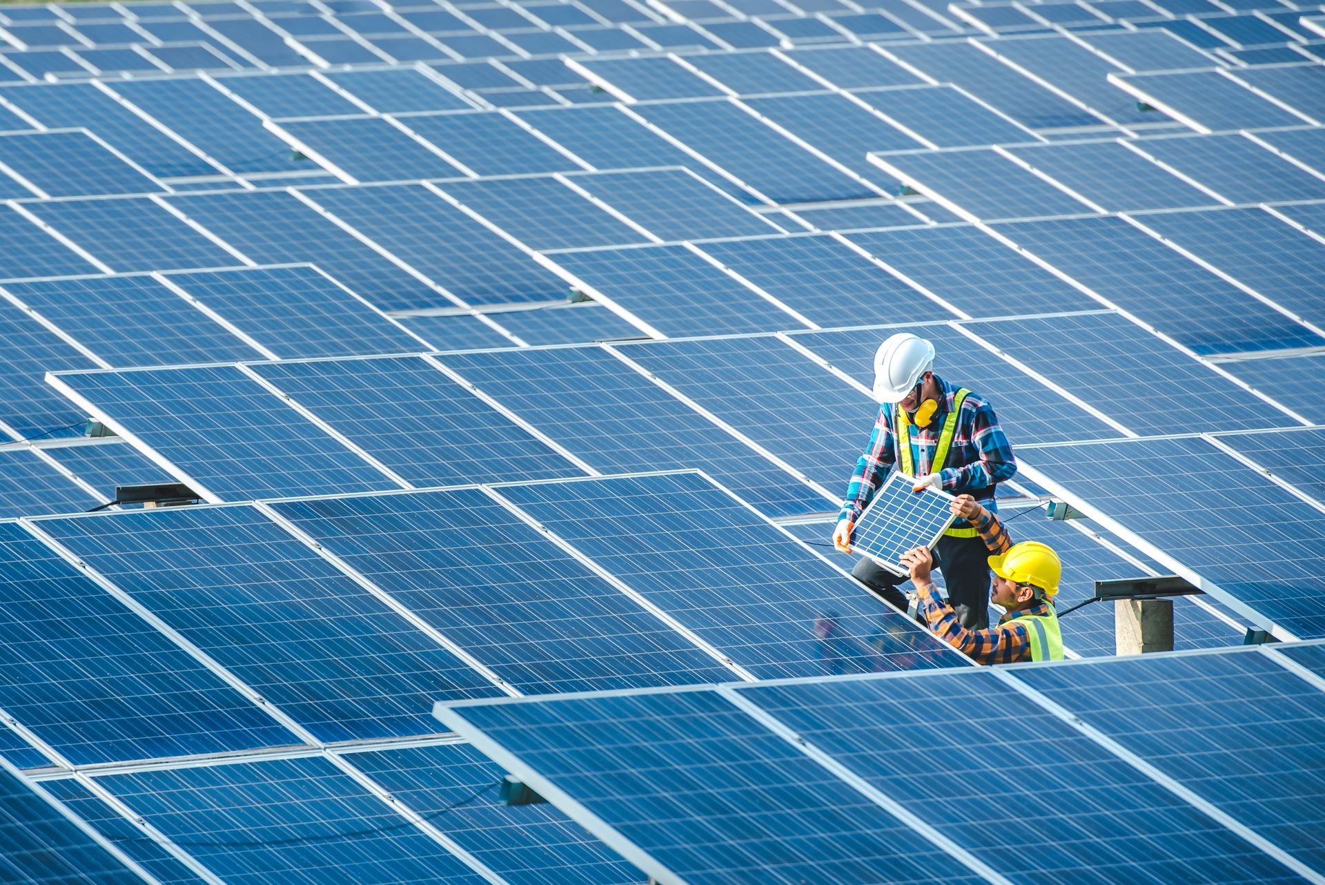 Workers conducting repairs on photovoltaic solar panels to restore energy production.