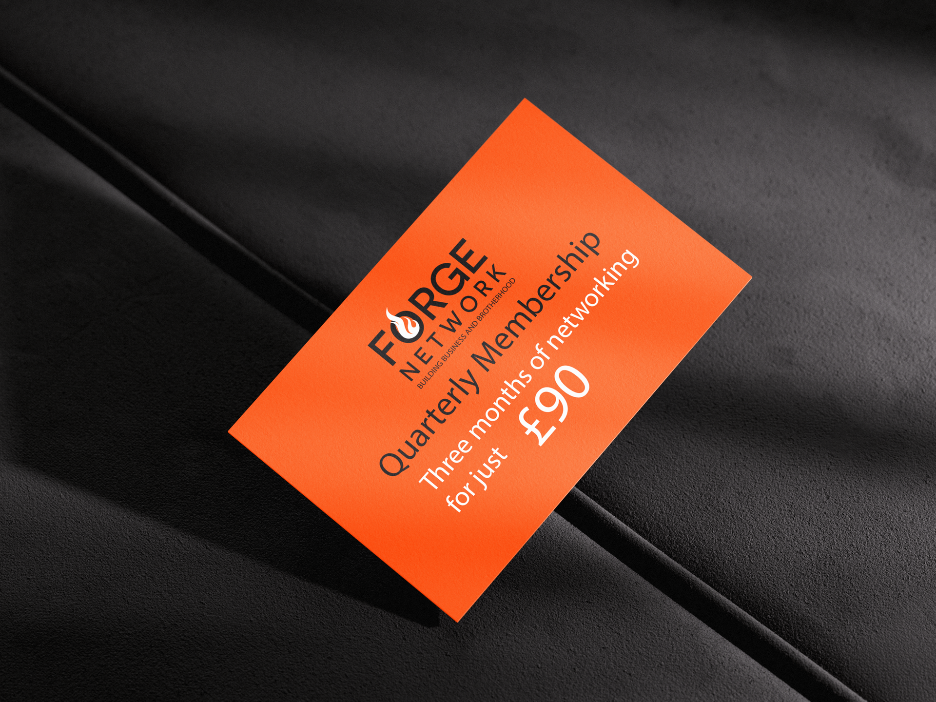 Orange tag on black surface, advertising Forge Network quarterly membership for £90.