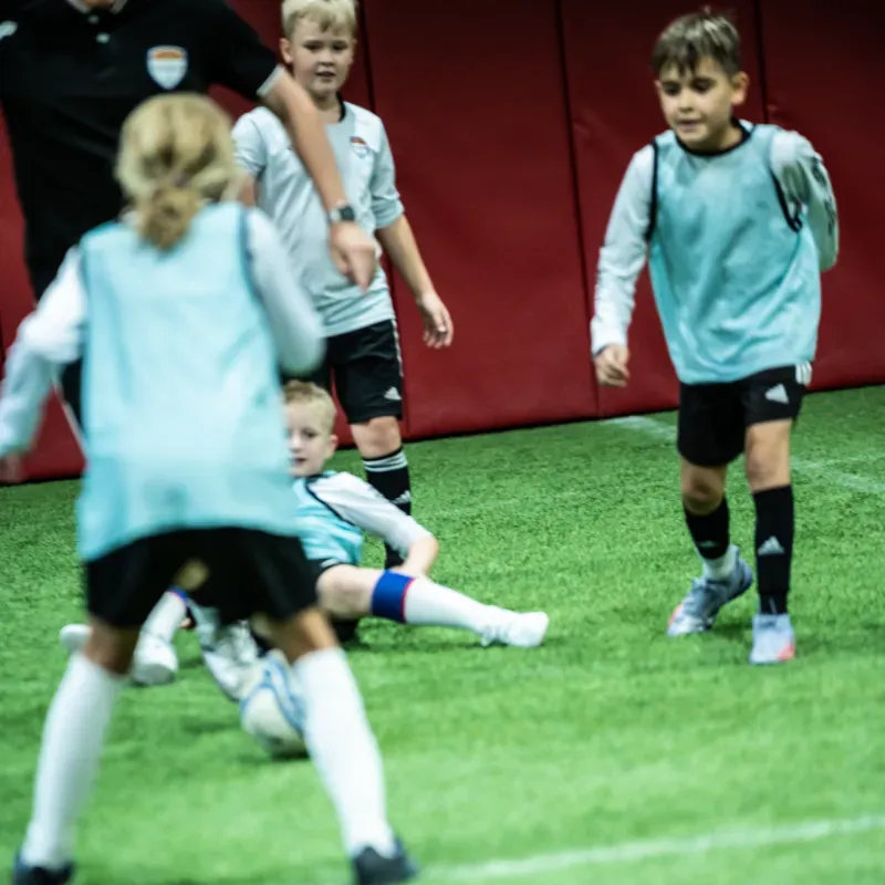 A group of young boys are playing soccer on a field.