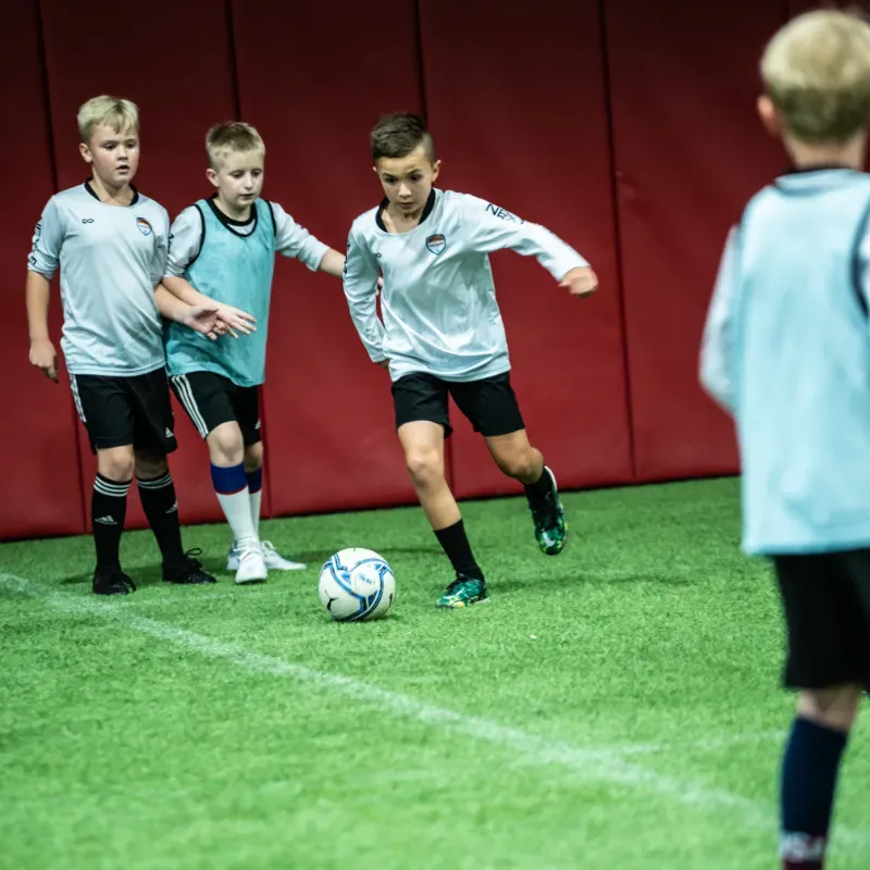 A group of young boys are playing soccer on a field