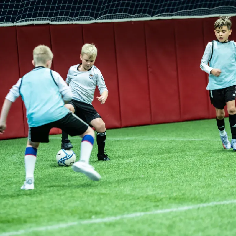 A group of young boys are playing soccer on a field