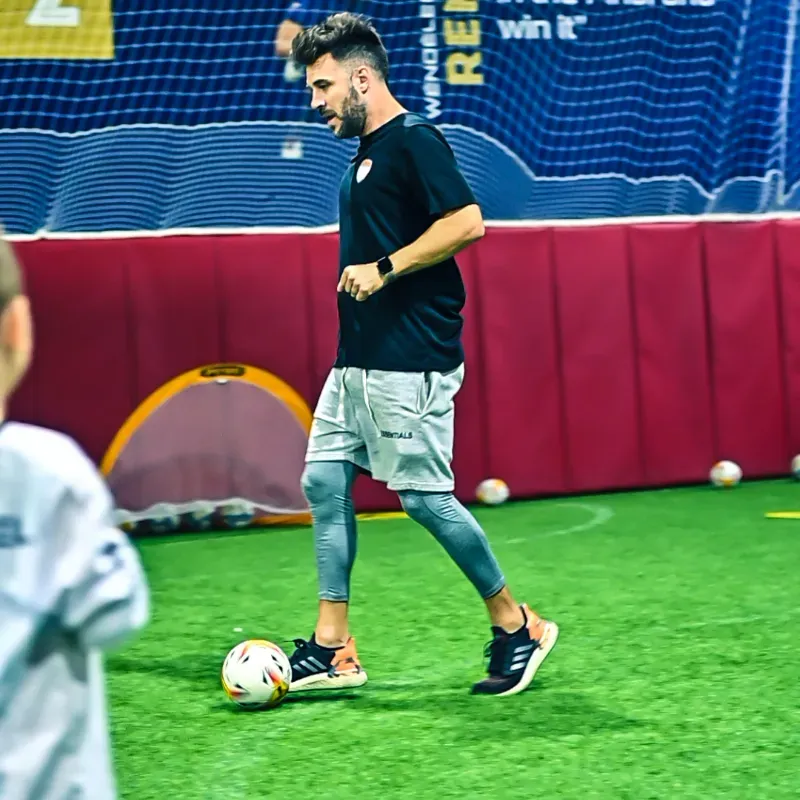 A man is kicking a soccer ball on a field