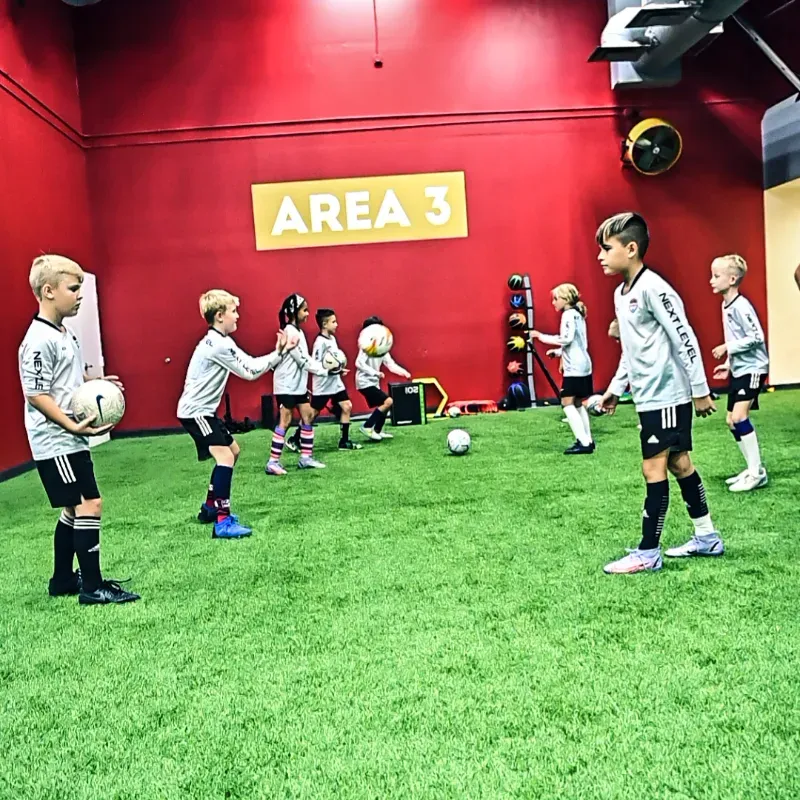 A group of children are playing soccer in area 3