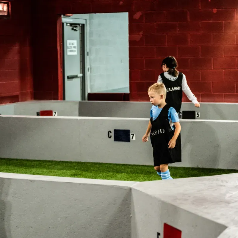 A boy wearing a black vest with the word clarks on it
