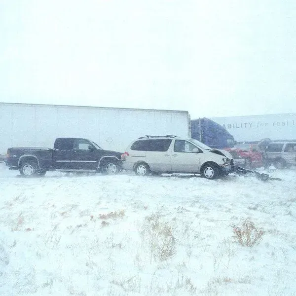 A truck and a minivan are parked in the snow.