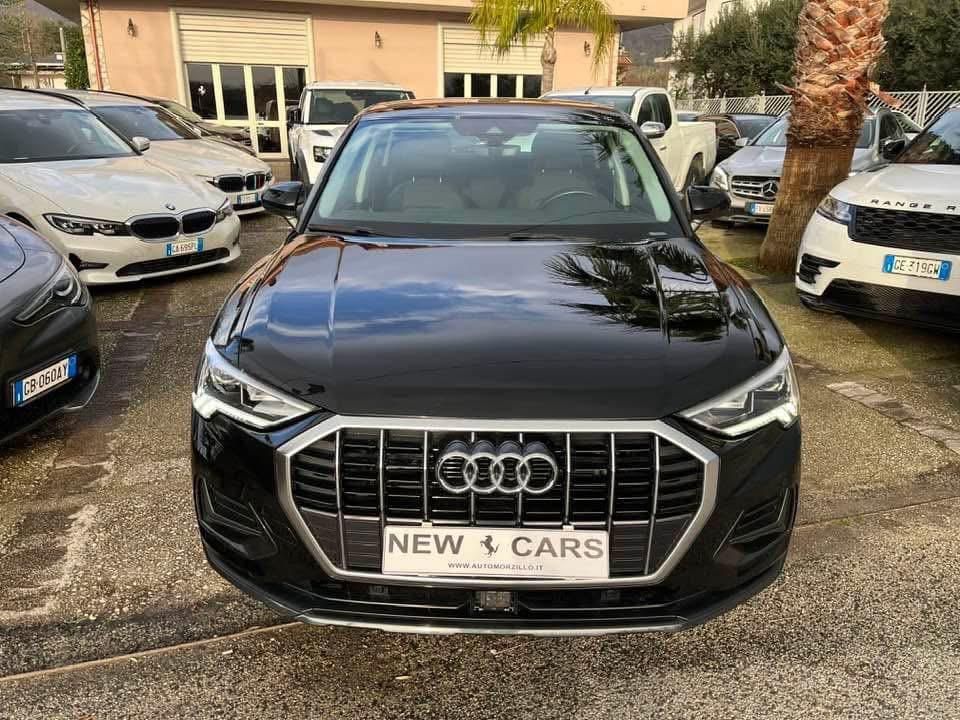 Interni neri dell'auto con cruscotto digitale che visualizza la navigazione, volante a sinistra.