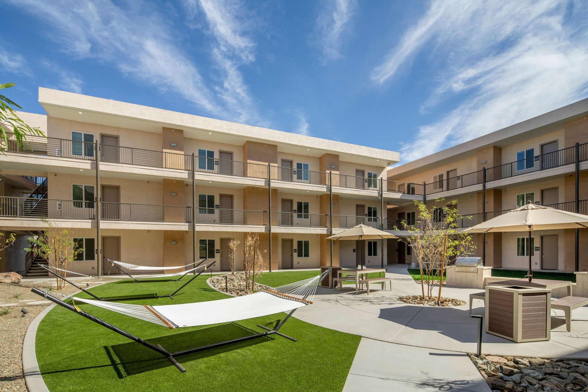 A large apartment building with a lush green lawn in front of it.