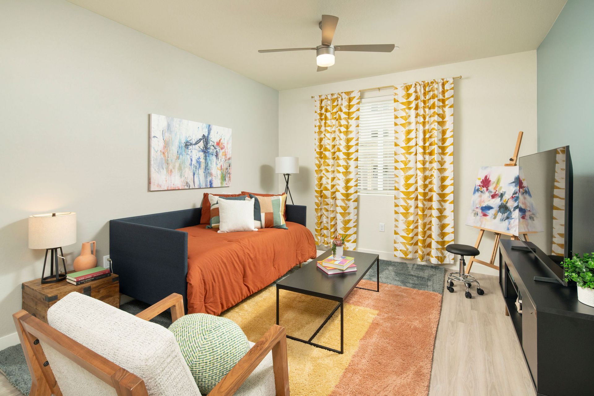 A living room with a couch , chair , coffee table and television.