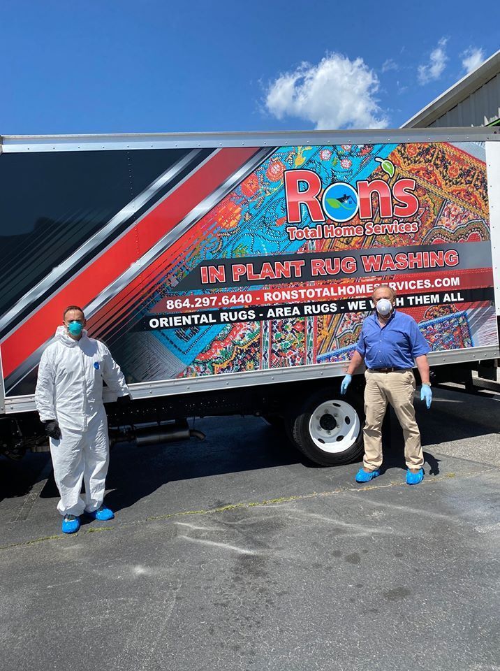 Two people in face masks stand by a service truck for 