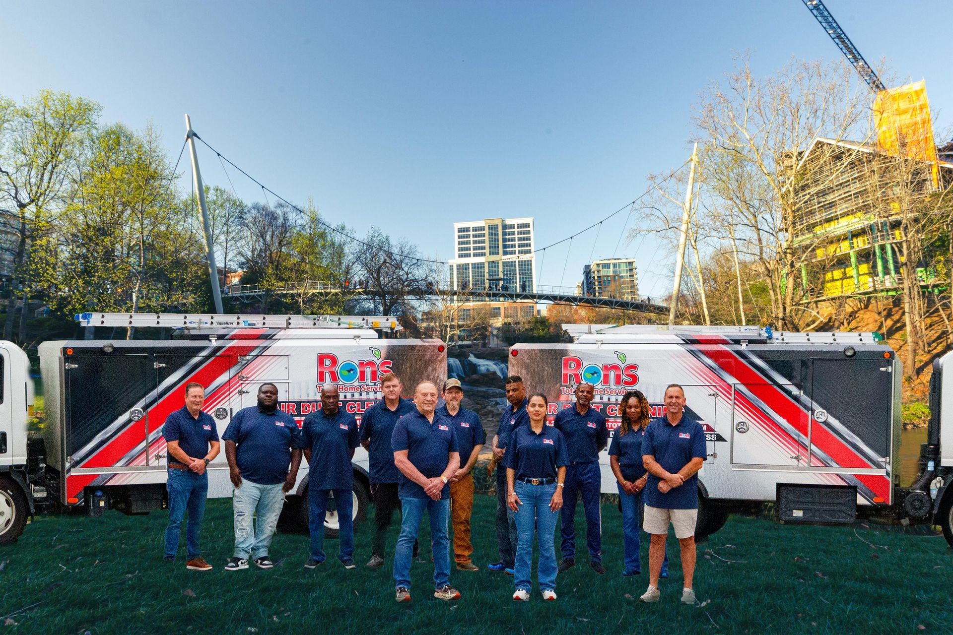 A team stands in front of two large trailers with 