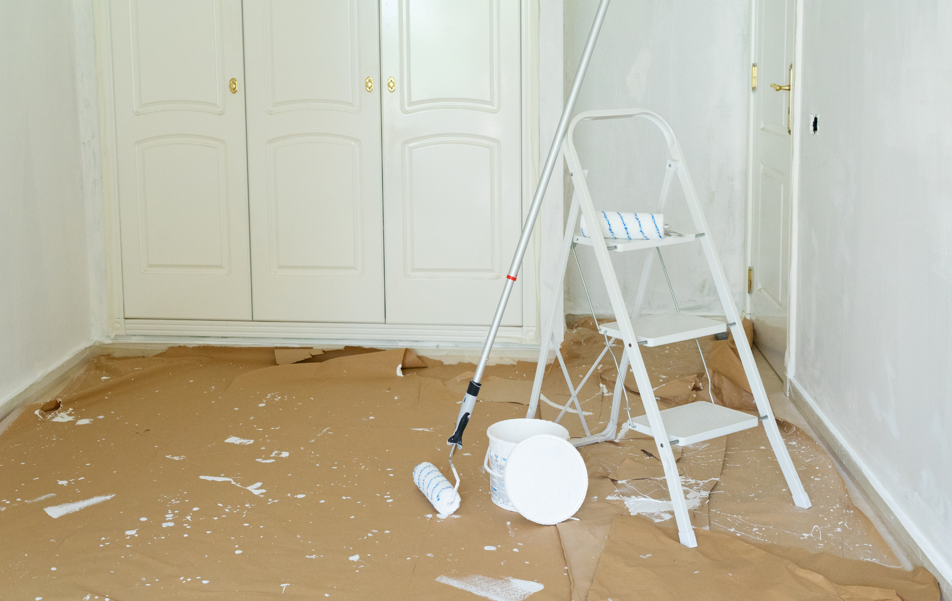 A person holding a green rotary brush attached to a red hose, preparing to clean a rectangular vent in a ceiling.