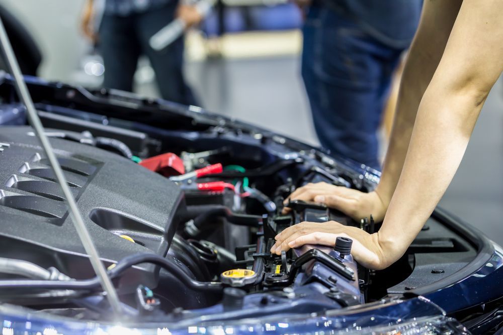 Close Up of Hands Leaning on A Car Engine Bay — Morisset Automotive in Morisset, NSW