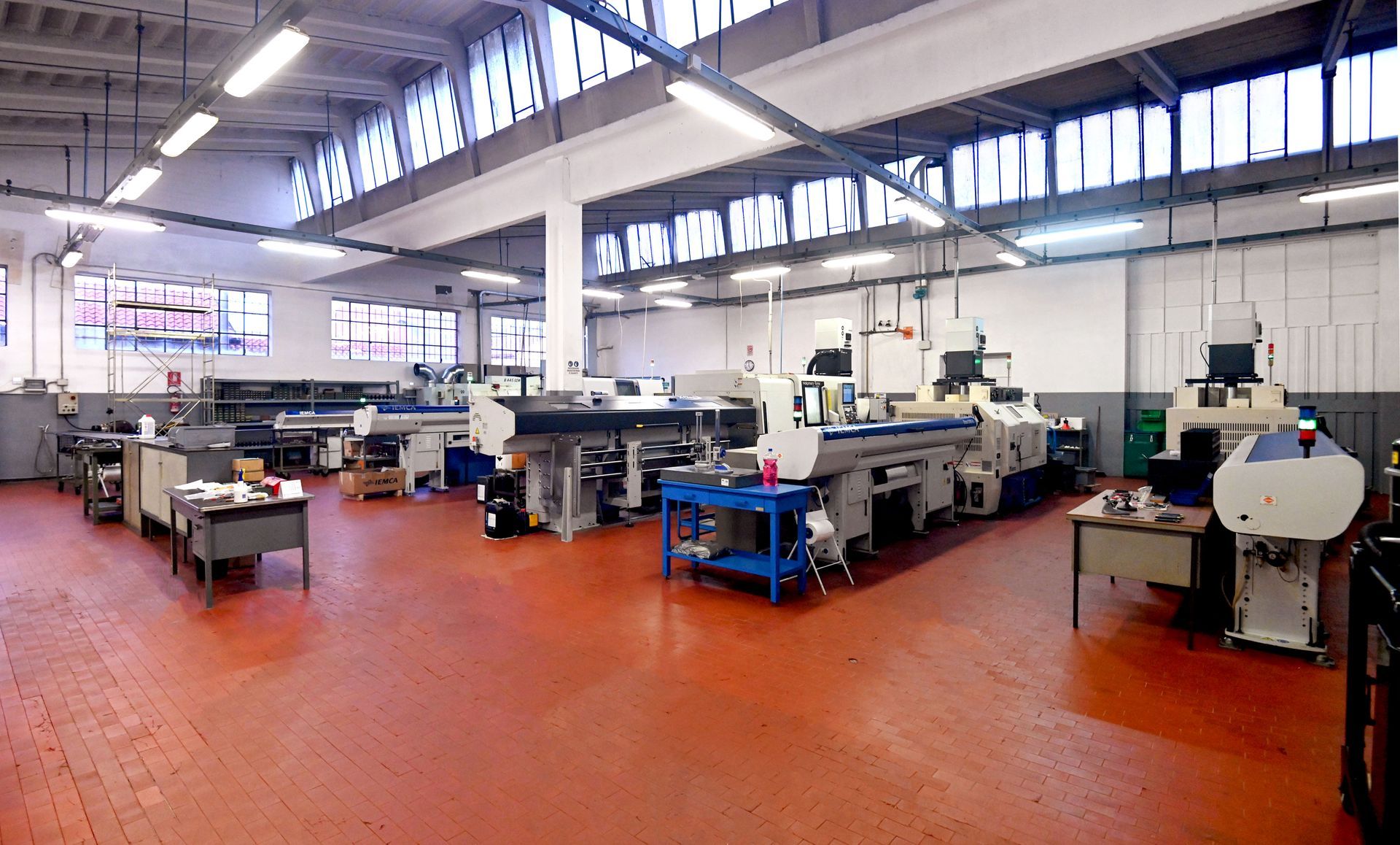 Un grande magazzino pieno di macchinari e tavoli.