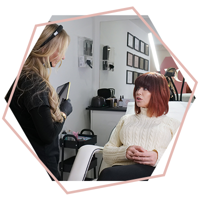 A woman is sitting in a chair talking to another woman.