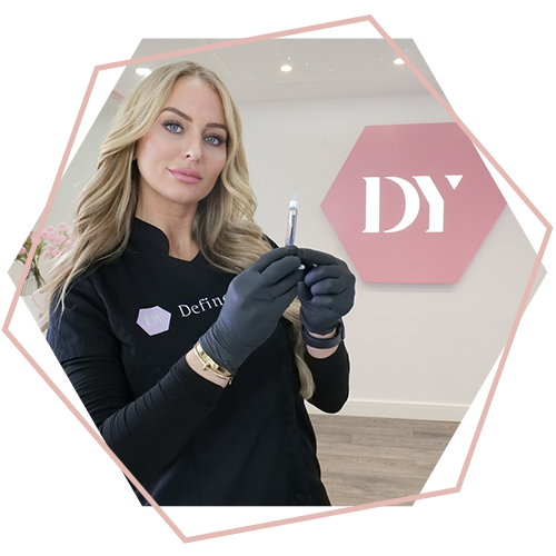 A woman is holding a syringe in front of a pink sign that says dy.