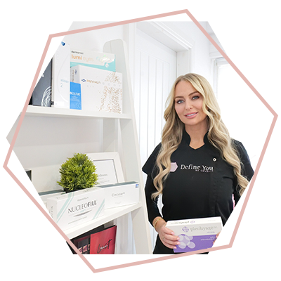 A woman is standing in front of a shelf holding a box.