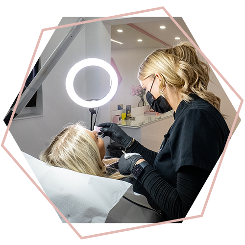 A woman is getting her eyebrows done in a salon.