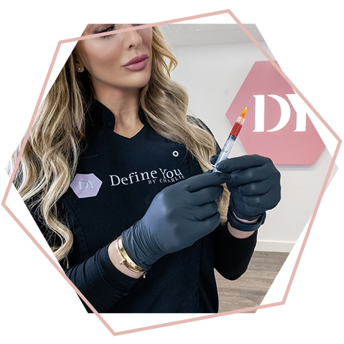 A woman in a define you shirt is holding a syringe in her hands.