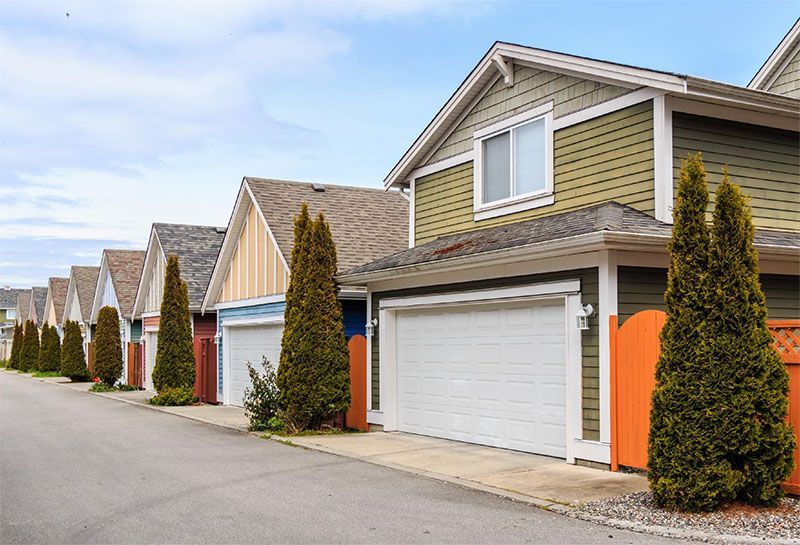 A row of houses with garages in a residential neighborhood.