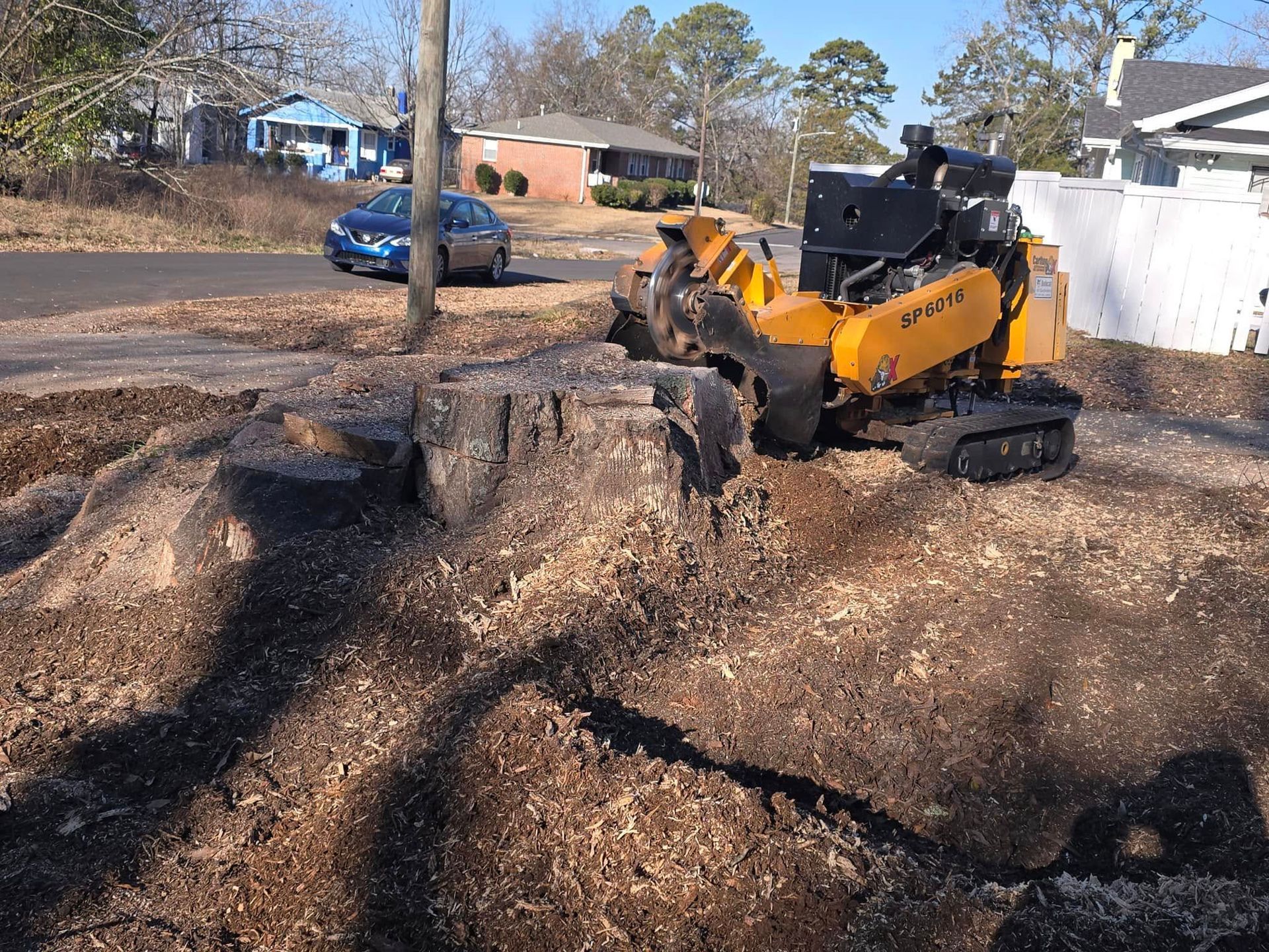 A large tree stump is being removed by an excavator. A large tree stump is being removed by an excavator.