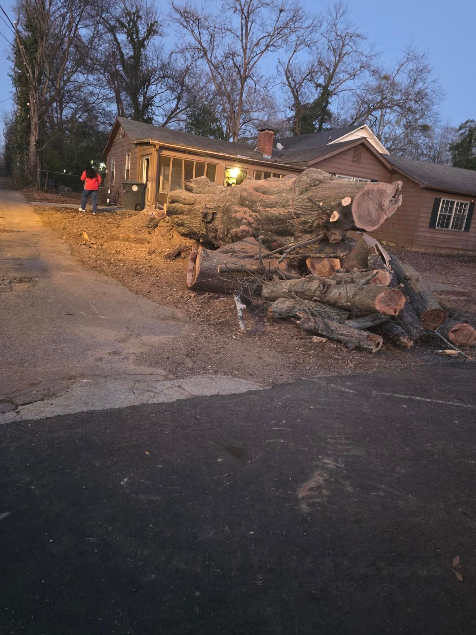 A pile of logs is sitting in front of a house. A pile of logs is sitting in front of a house.