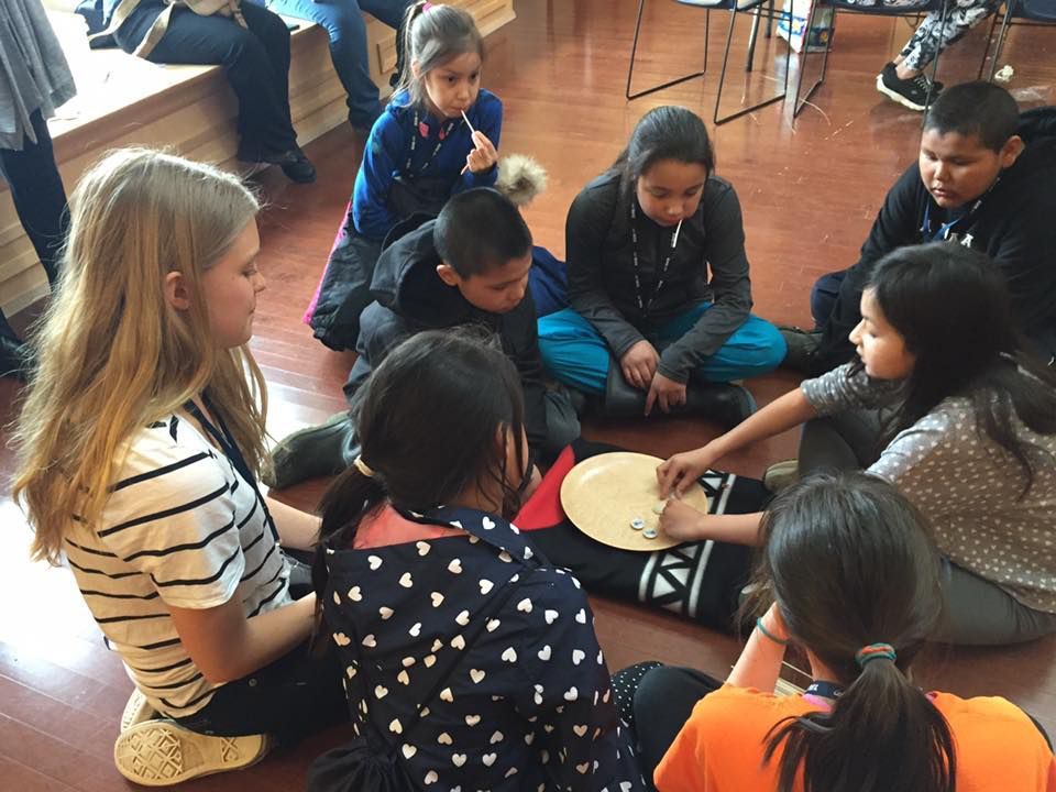 Children playing Waltes https://showmeyourmath.ca/outreach/games/ Children playing a traditional stick game together