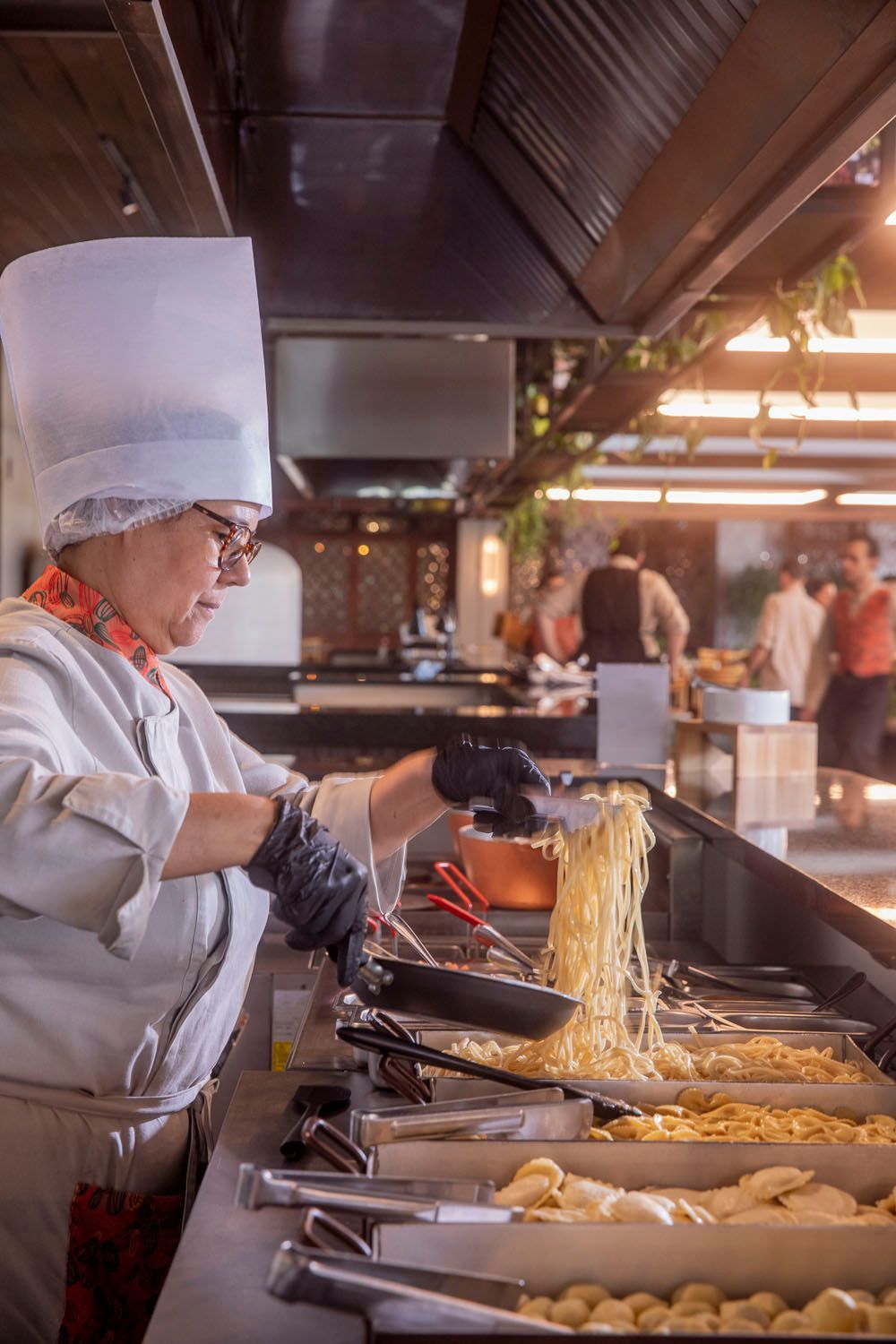 Um chef está preparando comida na cozinha de um restaurante.