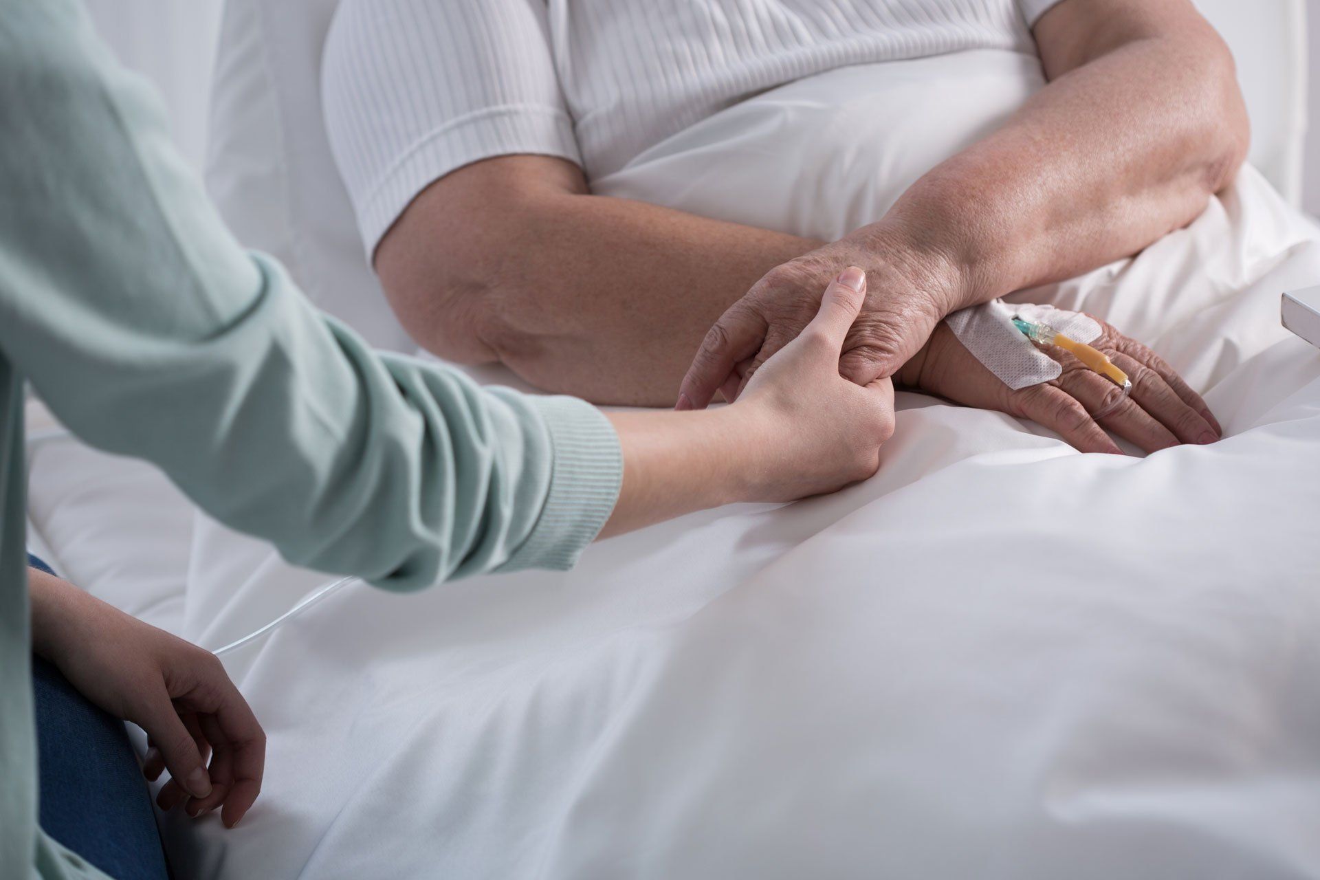 relative holding the hand of a patient