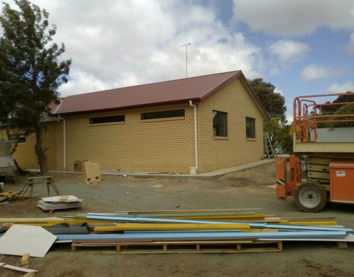 Exterior of a Brick Building Under Construction With a Red Roof — Daniher Building Company in Flynn, ACT