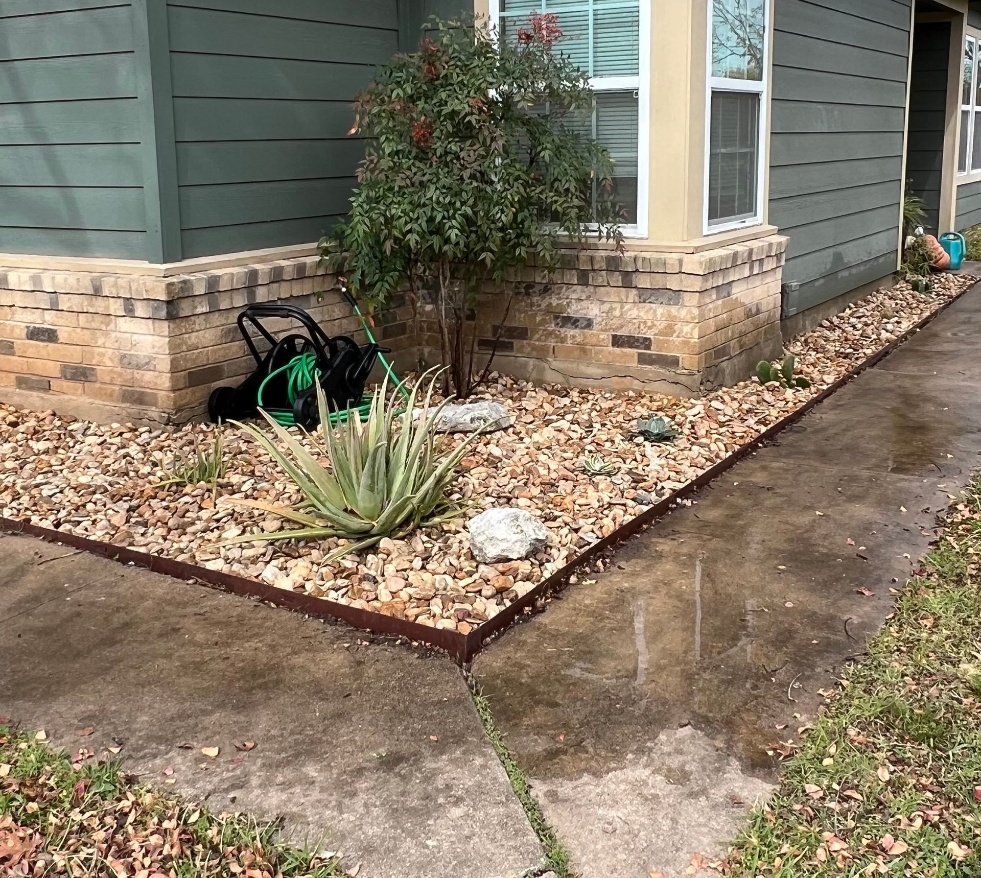 A lawn mower is sitting on the sidewalk in front of a house.