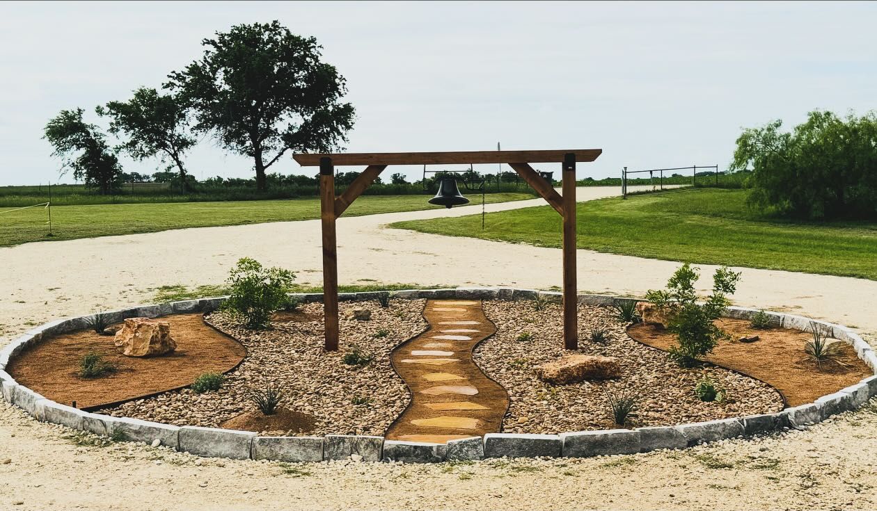 A wooden pergola is sitting in the middle of a dirt field. done by Labay Landscaping LLC.